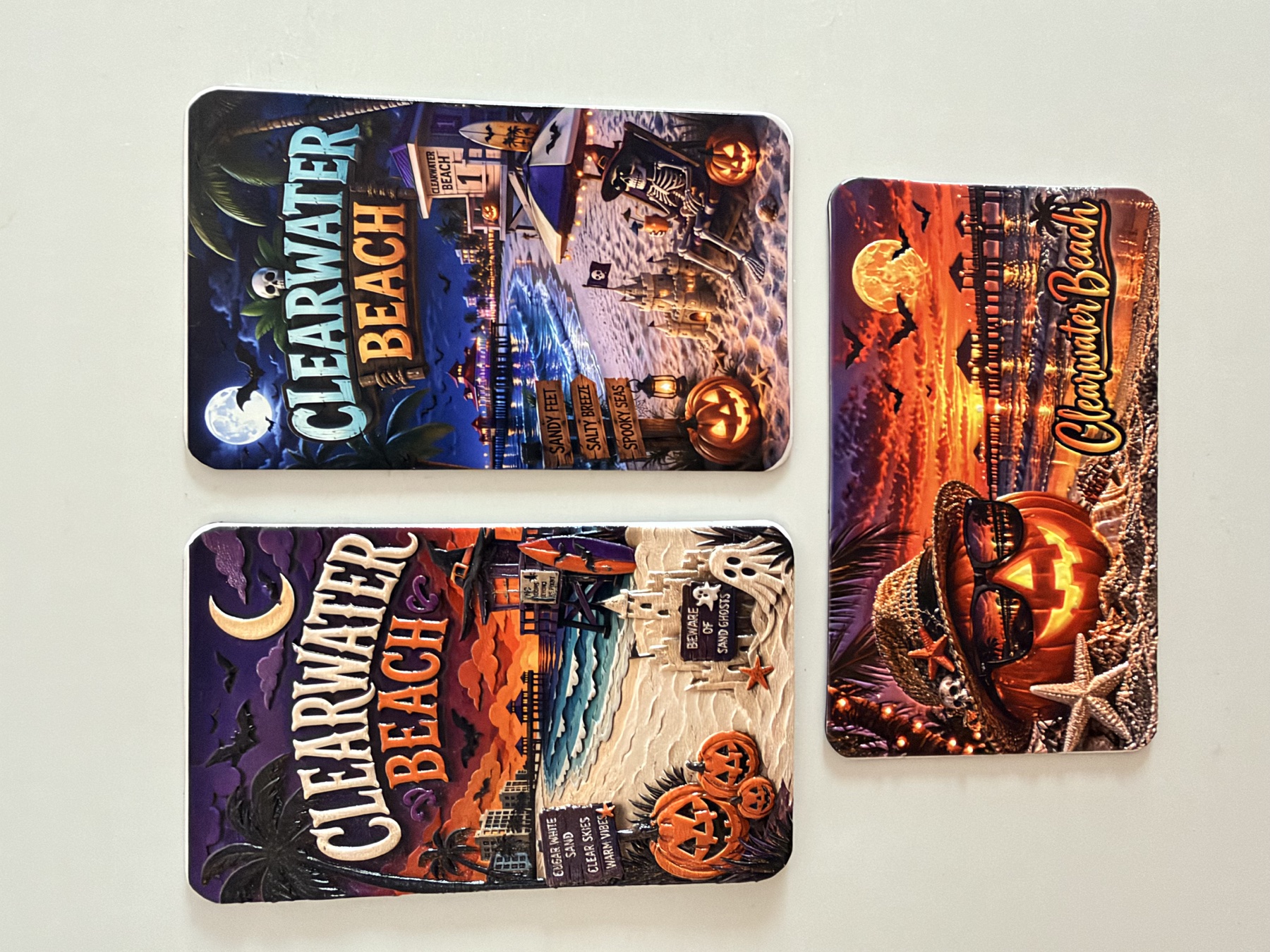 Three Clearwater Beach Halloween magnets with pumpkins, ghosts, a skeleton and colorful beach scenes