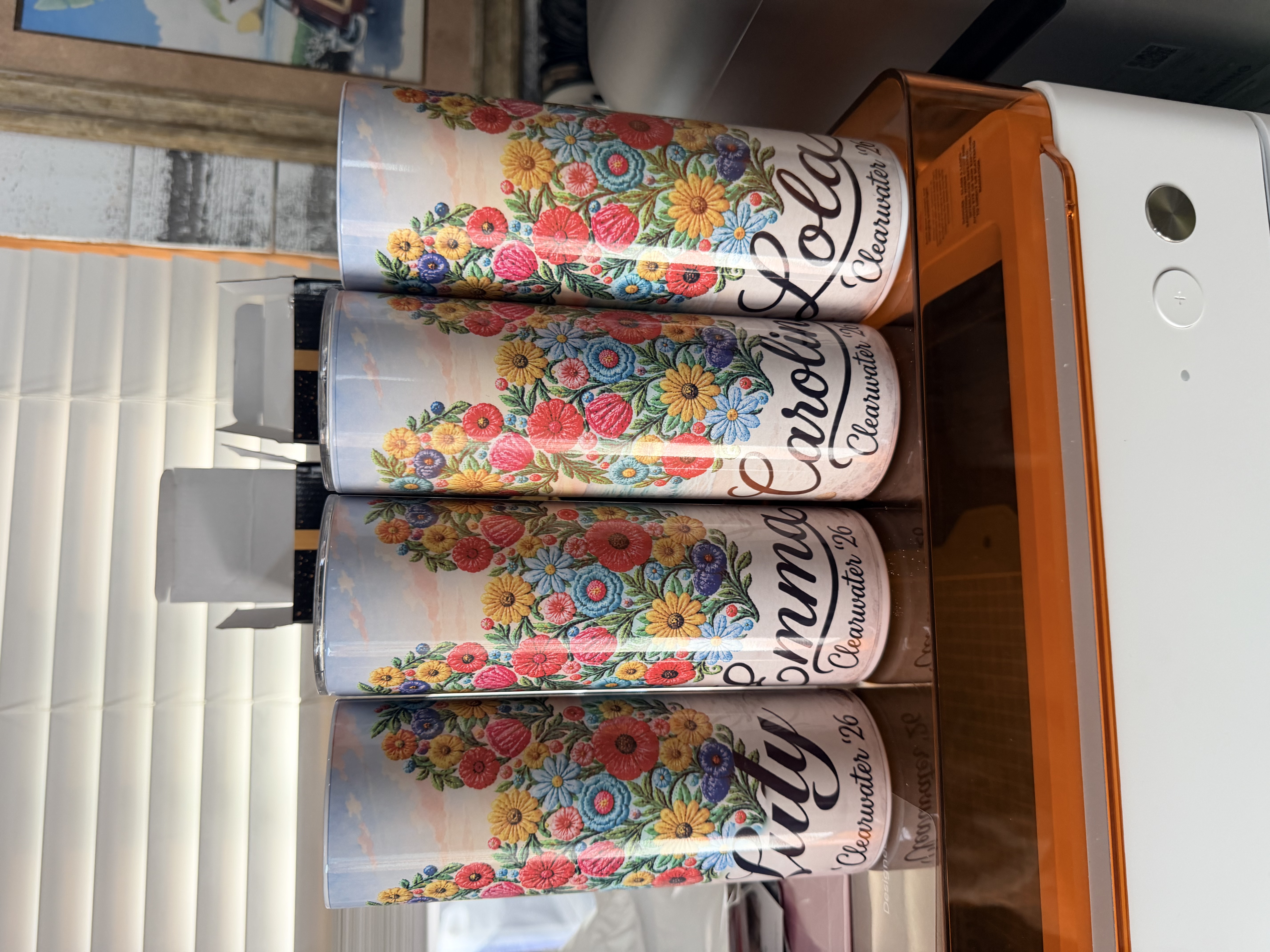 Four personalized tumblers with colorful floral Mickey Mouse ears and names, made by GTB Creations